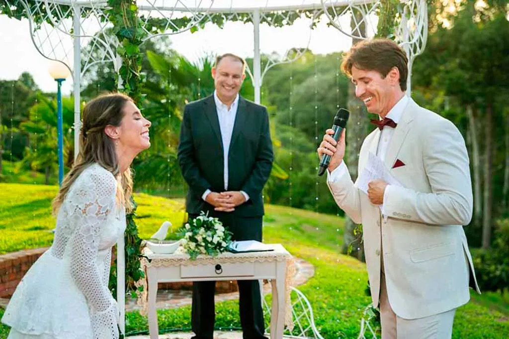 Ricardo conduz uma cerimônia íntima sob uma pérgola branca no jardim